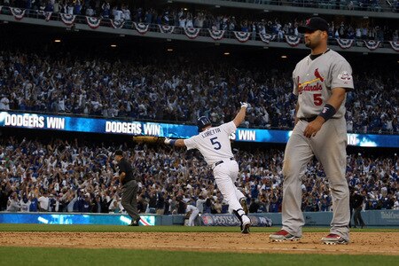 LOS ANGELES, CA - OCTOBER 08:  Mark Loretta #5 of the Los Angeles Dodgers reacts as he hits a walk-off RBI single to center to score Casey Blake #23 to defeat the St. Louis Cardinals as Albert Pujols #5 of the Cardinals walk off the field in Game Two of the NLDS during the 2009 MLB Playoffs at Dodger Stadium on October 8, 2009 in Los Angeles, California. The Dodgers defeated the Cardinals 3-2 to take a 2-0 series lead.  <br /><br /><span class="help">(Photo by Stephen Dunn/Getty Images)</span>