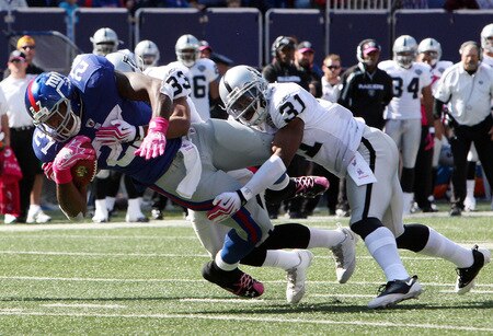 EAST RUTHERFORD, NJ - OCTOBER 11:  Brandon Jacobs #27 of the New York Giants is tackled by Tyvon Branch #33 and Hiram Eugene #31 of the Oakland Raiders on October 11, 2009 at Giants Stadium in East Rutherford, New Jersey.  <br /><br /><span class="help">(Photo by Jim McIsaac/Getty Images)</span>