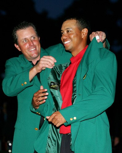 AUGUSTA, GA - APRIL 10: (FILE PHOTO)   Tiger Woods smiles as he is presented with the green jacket by Phil Mickelson after Woods won The Masters at the Augusta National Golf Club on April 10, 2005 in Augusta, Georgia. According to reports December 11, 2009, Woods announced that he would take an indefinite hiatus from golf.   <br /><br /><span class="help">(Photo by Harry How/Getty Images)</span>