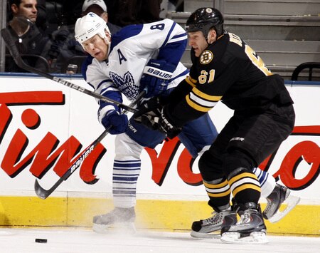 TORONTO - DECEMBER 19: Mike Komisarek #8 of the Toronto Maple Leafs is roughed up by Byron Bitz #61 of the Boston Bruins during game action December 19, 2009 at the Air Canada Centre in Toronto, Ontario, Canada. <br /><br /><span class="help">(Photo by Abelimages/Getty Images)</span>