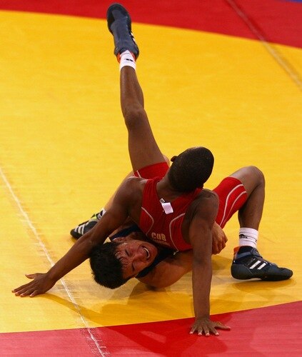 SINGAPORE - AUGUST 15: Shadybek Sulaimanov of Kyrgyzstan competes against Johan Rodriguez Banguela of Cuba in the Men's Greco Roman 50kg Wrestling competition on day one of the Youth Olympics at the International Convention Centre on August 15, 2010 in Singapore.  <br /><br /><span class="help">(Photo by Mark Dadswell/Getty Images)</span>