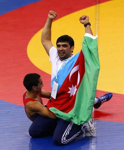 SINGAPORE - AUGUST 15:  Elman Mukhtarov of Azerbaijan celebrates winning the Gold medal with his coach Abdulov after defeating Nurbek Hakkulov of Uzbekistan in the Men's Greco Roman 50kg Wrestling competition on day one of the Youth Olympics at the International Convention Centre on August 15, 2010 in Singapore.  <br /><br /><span class="help">(Photo by Mark Dadswell/Getty Images)</span>