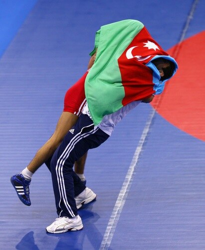 SINGAPORE - AUGUST 15:  Elman Mukhtarov of Azerbaijan celebrates winning the Gold medal with his coach Abdulov after defeating Nurbek Hakkulov of Uzbekistan in the Men's Greco Roman 50kg Wrestling competition on day one of the Youth Olympics at the International Convention Centre on August 15, 2010 in Singapore.  <br /><br /><span class="help">(Photo by Mark Dadswell/Getty Images)</span>