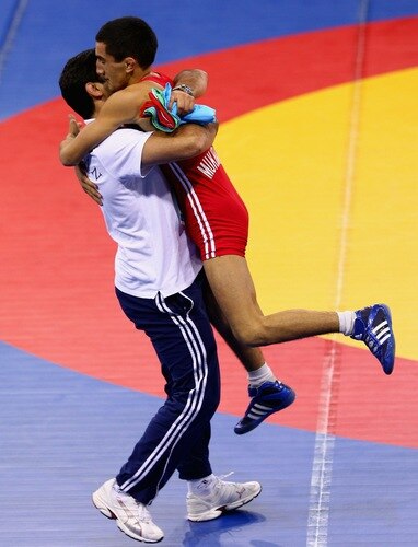 SINGAPORE - AUGUST 15:  Elman Mukhtarov of Azerbaijan celebrates winning the Gold medal with his coach Abdulov after defeating Nurbek Hakkulov of Uzbekistan in the Men's Greco Roman 50kg Wrestling competition on day one of the Youth Olympics at the International Convention Centre on August 15, 2010 in Singapore.  <br /><br /><span class="help">(Photo by Mark Dadswell/Getty Images)</span>