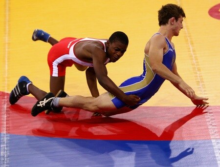 SINGAPORE - AUGUST 15:  Artur Suleymanov of the Russian Federation competes against Jason Afrikaner of Namibia in the Men's Greco Roman 58kg Wrestling competition on day one of the Youth Olympics at the International Convention Centre on August 15, 2010 in Singapore.  <br /><br /><span class="help">(Photo by Mark Dadswell/Getty Images)</span>