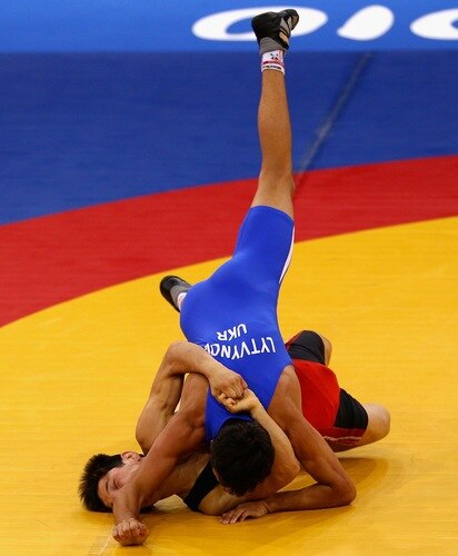 SINGAPORE - AUGUST 15:  Urmatbek Amatov of Kyrgyzstan competes against Olexander Lytvynov of the Ukraine in the final of the Men's Greco Roman 58kg Wrestling competition on day one of the Youth Olympics at the International Convention Centre on August 15, 2010 in Singapore.  <br /><br /><span class="help">(Photo by Mark Dadswell/Getty Images)</span>