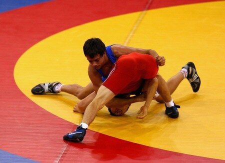 SINGAPORE - AUGUST 15:  Urmatbek Amatov of Kyrgyzstan competes against Olexander Lytvynov of the Ukraine in the final of the Men's Greco Roman 58kg Wrestling competition on day one of the Youth Olympics at the International Convention Centre on August 15, 2010 in Singapore.  <br /><br /><span class="help">(Photo by Mark Dadswell/Getty Images)</span>