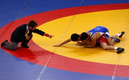 SINGAPORE - AUGUST 15:  Musa Gedik of Turkey competes against Zhanibek Kandybayev of Kazakhstan  in the final of the Men's Greco Roman 69kg Wrestling competition on day one of the Youth Olympics at the International Convention Centre on August 15, 2010 in Singapore.  <br /><br /><span class="help">(Photo by Mark Dadswell/Getty Images)</span>