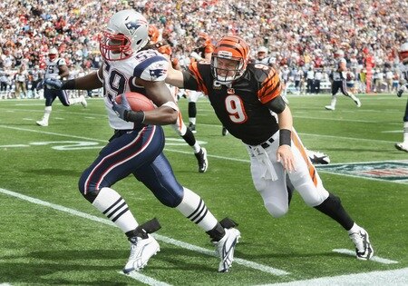 FOXBORO, MA - SEPTEMBER 12:  Gary Guyton #59 of the New England Patriots carries the ball in for a touchdown as Carson Palmer #9 of the Cincinnati Bengals tries to tackle during the NFL season opener on September 12, 2010 at Gillette Stadium in Foxboro, Massachusetts. Guyton intercepted Palmer's pass.  <br /><br /><span class="help">(Photo by Elsa/Getty Images)</span>