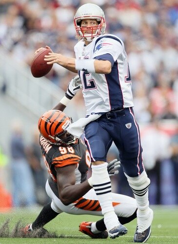 FOXBORO, MA - SEPTEMBER 12:  Tom Brady #12 of the New England Patriots scrambles as Antwan Odom #98 of the Cincinnati Bengals is unable to make the sack during the NFL season opener on September 12, 2010 at Gillette Stadium in Foxboro, Massachusetts.  <br /><br /><span class="help">(Photo by Elsa/Getty Images)</span>