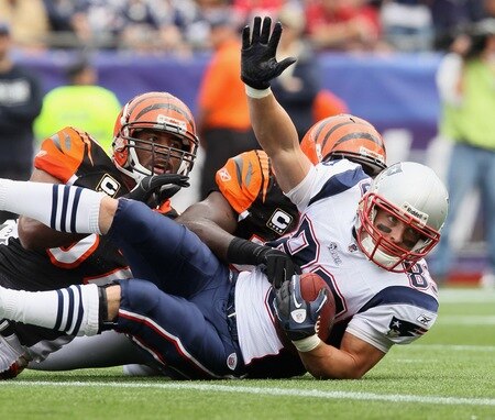 FOXBORO, MA - SEPTEMBER 12:  Wes Welker #83 of the New England Patriots falls into the endzone to score a touchdown as Dhani Jones #57 and Brandon Johnson #59 of the Cincinnati Bengals defend during the NFL season opener on September 12, 2010 at Gillette Stadium in Foxboro, Massachusetts.  <br /><br /><span class="help">(Photo by Elsa/Getty Images)</span>