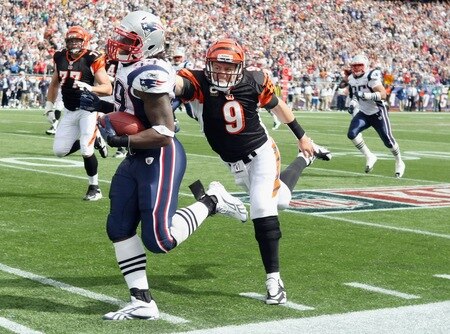 FOXBORO, MA - SEPTEMBER 12:  Gary Guyton #59 of the New England Patriots carries the ball in for a touchdown as Carson Palmer #9 of the Cincinnati Bengals tries to tackle during the NFL season opener on September 12, 2010 at Gillette Stadium in Foxboro, Massachusetts. Guyton intercepted Palmer's pass.  <br /><br /><span class="help">(Photo by Elsa/Getty Images)</span>