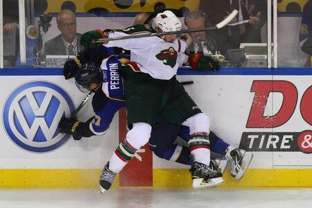 ST. LOUIS - SEPTEMBER 24: David Perron #57 of the St. Louis Blues is checked into the boards by Greg Zanon #5 of the Minnesota Wild during a pre-season game at the Scottrade Center on September 24, 2010 in St. Louis, Missouri.  <br /><br /><span class="help">(Photo by Dilip Vishwanat/Getty Images)</span>