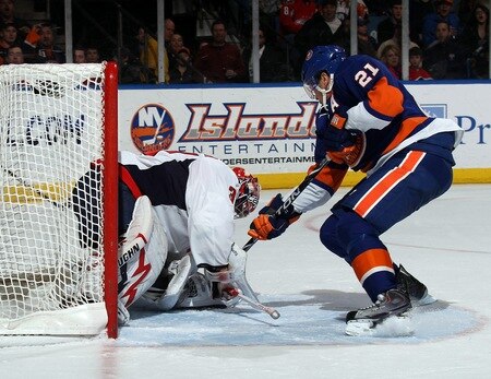 UNIONDALE, NY - FEBRUARY 26: Michal Neuvirth #30 of the Washington Capitals covers the puck as Kyle Okposo #21 of the New York Islanders looks for a rebound at the Nassau Coliseum on February 26, 2011 in Uniondale, New York. <br /><br /><span class="help">(Photo by Bruce Bennett/Getty Images)</span>