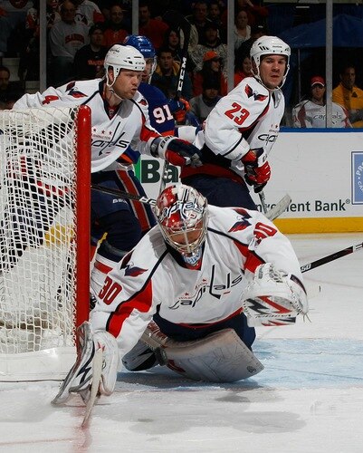 UNIONDALE, NY - FEBRUARY 26:  Goaltender Michal Neuvirth #30 of the Washington Capitals tries to cover the loose puck as teammates John Erskine #4 and Scott Hannan #23 help out defending the net in a game against the New York Islanders on February 26, 2011 at Nassau Coliseum in Uniondale, New York.  <br /><br /><span class="help">(Photo by Mike Stobe/NHLI via Getty Images)</span>