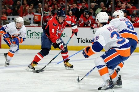 WASHINGTON, DC - MARCH 01:  Alex Ovechkin #8 of the Washington Capitals shoots the puck against past Bruno Gervais #8 and Jack Hillen #38 of the New York Islanders at the Verizon Center on March 1, 2011 in Washington, DC.  The Capitals won the game 2-1.  <br /><br /><span class="help">(Photo by Greg Fiume/Getty Images)</span>