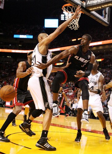 MIAMI - MARCH 14:  Guard Dwyane Wade #3 of the Miami Heat passes  against Center Tim Duncan #21 of the San Antonio Spurs at American Airlines Arena on March 14, 2011 in Miami, Florida. <br /><br /><span class="help">(Photo by Marc Serota/Getty Images)</span>