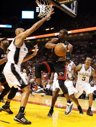 MIAMI - MARCH 14:  Guard Dwyane Wade #3 of the Miami Heat passes  against Center Tim Duncan #21 of the San Antonio Spurs at American Airlines Arena on March 14, 2011 in Miami, Florida. <br /><br /><span class="help">(Photo by Marc Serota/Getty Images)</span>