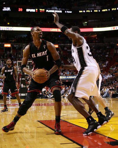 MIAMI - MARCH 14:  Forward Chris Bosh #1 of the Miami Heat drives against DeJuan Blair #34 of the San Antonio Spurs at American Airlines Arena on March 14, 2011 in Miami, Florida. The Heat defeated the Spurs 110-80. <br /><br /><span class="help">(Photo by Marc Serota/Getty Images)</span>
