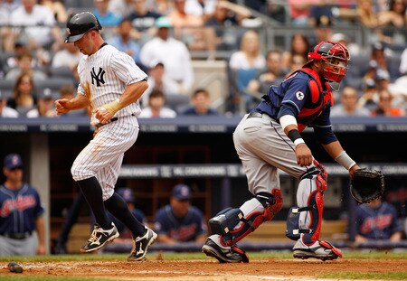 NEW YORK - JUNE 12:  Brett Gardner #11 of the New York Yankees scores on teammates Curtis Granderson #14 (not pictured) sacrifice fly as catcher Carlos Santana #41 of the Cleveland Indians wait for the throw on June 12, 2011 at Yankee Stadium in the Bronx borough of New York City.  <br /><br /><span class="help">(Photo by Mike Stobe/Getty Images)</span>
