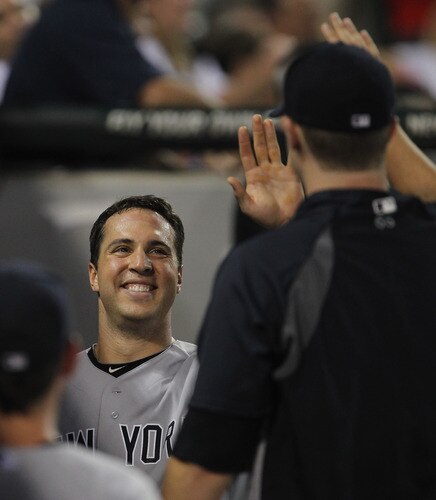 CHICAGO, IL - AUGUST 03: Mark Teixiera #25 of the New York Yankees smiles as he is greeted by teammates in the dugout after hitting a run-scoring triple and then scoring in the 3rd inning against the Chicago White Sox at U.S. Cellular Field on August 3, 2011 in Chicago, Illinois. <br /><br /><span class="help">(Photo by Jonathan Daniel/Getty Images)</span>