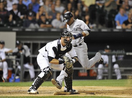 CHICAGO, IL - AUGUST 04:  Robinson Cano #24 (R) of the New York Yankees scores on an RBI single hit by teammate Jorge Posada #20 as catcher A. J. Pierzynski #12 of the Chicago White Sox waits for the throw from the outfield during the seventh inning at U.S. Cellular Field on August 4, 2011 in Chicago, Illinois.  <br /><br /><span class="help">(Photo by Brian Kersey/Getty Images)</span>