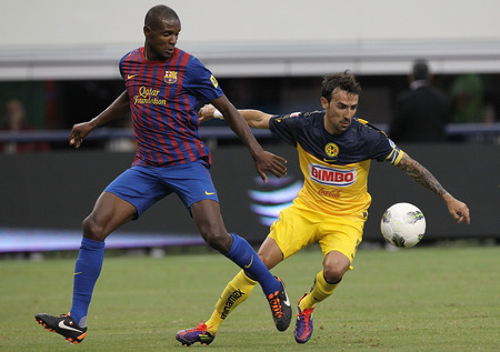 ARLINGTON, TX - AUGUST 06: Vicente Sanchez #8 of Club America dribbles the ball against Eric Abidal #22 of FC Barcelona at Cowboys Stadium on August 6, 2011 in Arlington, Texas. <br /><br /><span class="help">(Photo by Ronald Martinez/Getty Images)</span>