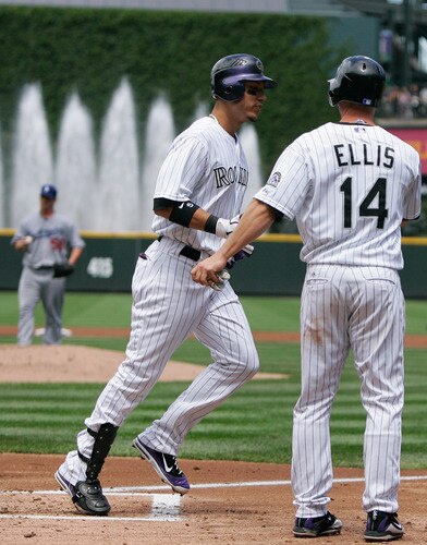 DENVER, CO - AUGUST 21:  Carlos Gonzalez #5 of the Colorado Rockies is congratulated by Mark Ellis #14 at home plate after hitting a home run off of Chad Billingsley #58 of the Los Angeles Dodgers during the first inning at Coors Field on August 21, 2011 in Denver, Colorado.  <br /><br /><span class="help">(Photo by Justin Edmonds/Getty Images)</span>