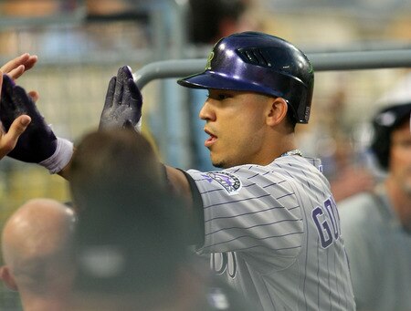 LOS ANGELES, CA - AUGUST 26:  Carlos Gonzalez #5 of the Colorado Rockies celebrates his first inning home run with teammates in the dugout during the MLB game against the Los Angeles Dodgers at Dodger Stadium on August 26, 2011 in Los Angeles, California.  <br /><br /><span class="help">(Photo by Victor Decolongon/Getty Images)</span>