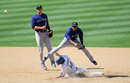 LOS ANGELES, CA - AUGUST 28:  Jonathan Herrera #18 of the Colorado Rockies throws to first base after getting the force out on Jamey Carroll #14 of the Los Angeles Dodgers at second base in the sixth inning as Troy Tulowitzki #2 of the Colorado Rockies looks on during the MLB game at Dodger Stadium on August 28, 2011 in Los Angeles, California. The Rockies defeated the Dodgers 7-6. <br /><br /><span class="help">(Photo by Victor Decolongon/Getty Images)</span>