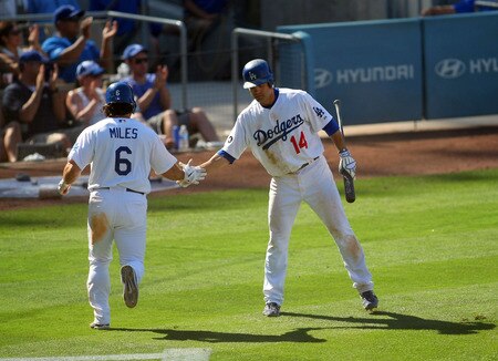 LOS ANGELES, CA - AUGUST 28:  Jamey Carroll #14 of the Los Angeles Dodgers congratulates teammate Aaron Miles #6 after Miles scored on a single to right-center field by Trent Oeltjen #49 (not in photo) of the Dodgers in the seventh inning during the MLB game against the Colorado Rockies at Dodger Stadium on August 28, 2011 in Los Angeles, California. The Rockies defeated the Dodgers 7-6.  <br /><br /><span class="help">(Photo by Victor Decolongon/Getty Images)</span>