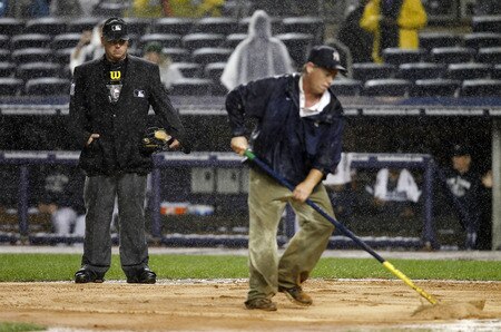 NEW YORK - SEPTEMBER 06:  Umpire Rob Drake watches as head groundskeeper Danny Cunningham attempts to dry the area around home plate during a game between the New York Yankees and the Baltimore Orioles at Yankee Stadium on September 6, 2011 in the Bronx Borough of New York City.  <br /><br /><span class="help">(Photo by Jeff Zelevansky/Getty Images)</span>