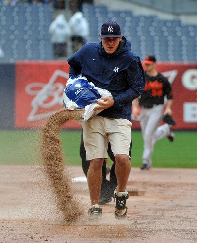 NEW YORK, NY - SEPTEMBER 07: A member of the New York Yankees grounds crew tends to the field in the middle of the sixth inning due to heavy rain during the game between the Baltimore Orioles and New York Yankees on September 7, 2011 at Yankee Stadium in the Bronx borough of New York City. <br /><br /><span class="help">(Photo by Christopher Pasatieri/Getty Images)</span>