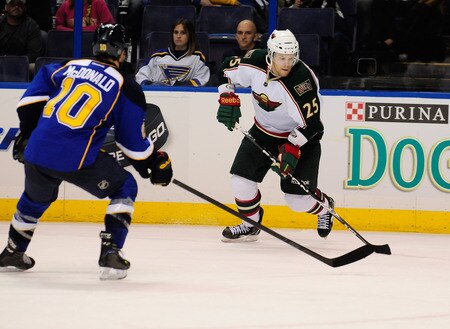 ST. LOUIS, MO - SEPTEMBER 22: Jordan Hendry #25 of the Minnesota Wild handles the puck as Andy McDonald #10 of the St. Louis Blues defends at Scottrade Center on September 22, 2011 in St. Louis, Missouri.  <br /><br /><span class="help">(Photo by Jeff Curry/Getty Images)</span>