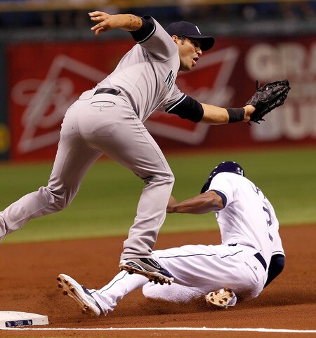 ST. PETERSBURG, FL - SEPTEMBER 26:  Infielder Eric Chavez #12 of the New York Yankees takes the throw at third as B.J. Upton #2 of the Tampa Bay Rays slides in safely during the game at Tropicana Field on September 26, 2011 in St. Petersburg, Florida.  <br /><br /><span class="help">(Photo by J. Meric/Getty Images)</span>