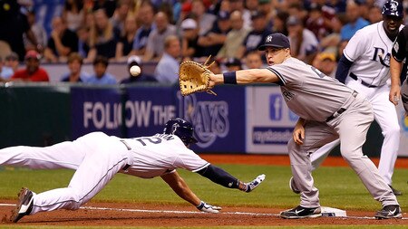 ST. PETERSBURG, FL - SEPTEMBER 27:  First baseman Mark Teixeira #25 of the New York Yankees takes the throw at first as Johnny Damon #22 of the Tampa Bay Rays gets back safely during the game at Tropicana Field on September 27, 2011 in St. Petersburg, Florida.  <br /><br /><span class="help">(Photo by J. Meric/Getty Images)</span>