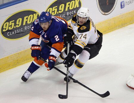 BRIDGEPORT, CT - OCTOBER 01:  Mark Streit #2 of the New York Islanders and Max Sauve #74 of the Boston Bruins battle for the puck at the Webster Bank Arena on October 1, 2011 in Bridgeport, Connecticut.  <br /><br /><span class="help">(Photo by Bruce Bennett/Getty Images)</span>