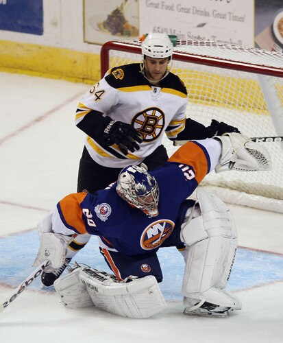 BRIDGEPORT, CT - OCTOBER 01: Evgeni Nabokov #20 of the New York Islanders is bumped by Lane MacDermid #64 of the Boston Bruins at the Webster Bank Arena on October 1, 2011 in Bridgeport, Connecticut.  <br /><br /><span class="help">(Photo by Bruce Bennett/Getty Images)</span>