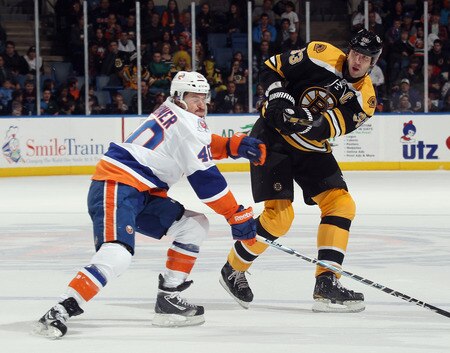 UNIONDALE, NY - NOVEMBER 19: Zdeno Chara #33 of the Boston Bruins shoots the puck into the offensive zone past Michael Grabner #40 of the New York Islanders at the Nassau Veterans Memorial Coliseum on November 19, 2011 in Uniondale, New York.  <br /><br /><span class="help">(Photo by Bruce Bennett/Getty Images)</span>