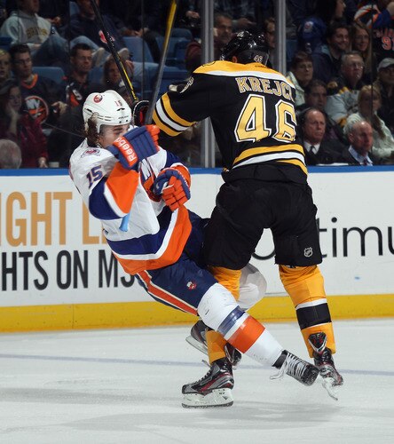 UNIONDALE, NY - NOVEMBER 19: David Krejci #46 of the Boston Bruins hits P.A. Parenteau #15 of the New York Islanders at the Nassau Veterans Memorial Coliseum on November 19, 2011 in Uniondale, New York. The Bruins defeated the Islanders 6-0. <br /><br /><span class="help">(Photo by Bruce Bennett/Getty Images)</span>