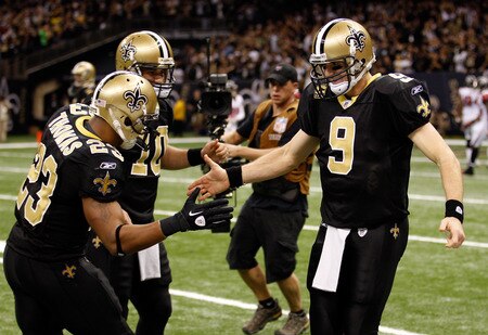 NEW ORLEANS, LA - DECEMBER 26:  (R) Quarterback Drew Brees #9 of the New Orleans Saints celebrates throwing a 24-yard third quarter touchdown pass with running back Pierre Thomas #23 and quarterback Chase Daniel #10 against the Atlanta Falcons at the Mercedes-Benz Superdome on December 26, 2011 in New Orleans, Louisiana.  <br /><br /><span class="help">(Photo by Chris Graythen/Getty Images)</span>