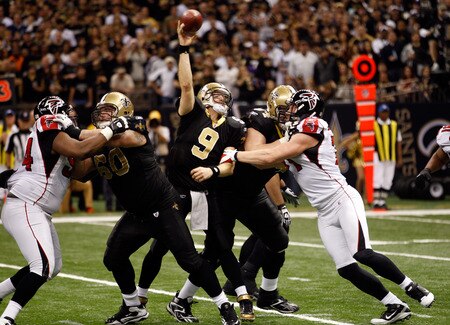 NEW ORLEANS, LA - DECEMBER 26:  Quarterback Drew Brees #9 of the New Orleans Saints throws the ball as his left arm is held by defensive end Kroy Biermann #71 of the Atlanta Falcons in the third quarter at the Mercedes-Benz Superdome on December 26, 2011 in New Orleans, Louisiana.  <br /><br /><span class="help">(Photo by Chris Graythen/Getty Images)</span>