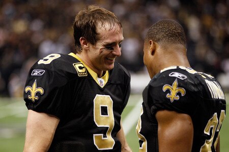 NEW ORLEANS, LA - DECEMBER 26:  Quarterback Drew Brees #9 of the New Orleans Saints smiles as he talks with running back Pierre Thomas #23 after Brees throws a nine-yard touchdown pass to running back Darren Sproles #43 and breaks the single-season passing record in the fourth quarter against the Atlanta Falcons at the Mercedes-Benz Superdome on December 26, 2011 in New Orleans, Louisiana.  <br /><br /><span class="help">(Photo by Chris Graythen/Getty Images)</span>