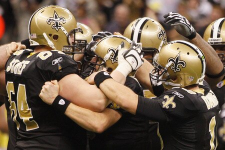 NEW ORLEANS, LA - DECEMBER 26:  Quarterback Drew Brees #9 of the New Orleans Saints is surrounded by his team after Brees throws a nine-yard touchdown pass to running back Darren Sproles #43 and breaks the single-season passing record in the fourth quarter against the Atlanta Falcons at the Mercedes-Benz Superdome on December 26, 2011 in New Orleans, Louisiana.   <br /><br /><span class="help">(Photo by Chris Graythen/Getty Images)</span>