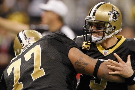 NEW ORLEANS, LA - DECEMBER 26:  Quarterback Drew Brees #9 of the New Orleans Saints is picked up by offensive guard Carl Nicks #77 after Brees throws a nine-yard touchdown pass to running back Darren Sproles #43 and breaks the single-season passing record in the fourth quarter against the Atlanta Falcons at the Mercedes-Benz Superdome on December 26, 2011 in New Orleans, Louisiana.  <br /><br /><span class="help">(Photo by Chris Graythen/Getty Images)</span>