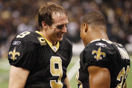 NEW ORLEANS, LA - DECEMBER 26:  Quarterback Drew Brees #9 of the New Orleans Saints celebrates with Pierre Thomas #23 after Brees throws a nine-yard touchdown pass to running back Darren Sproles #43 and breaks the single-season passing record in the fourth quarter against the Atlanta Falcons at the Mercedes-Benz Superdome on December 26, 2011 in New Orleans, Louisiana.  <br /><br /><span class="help">(Photo by Chris Graythen/Getty Images)</span>