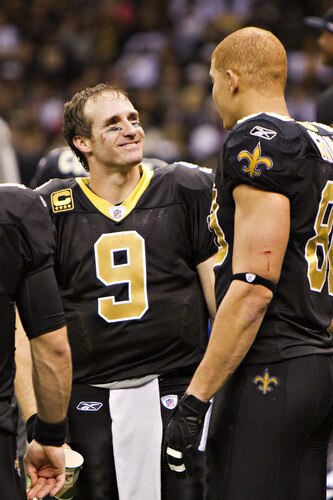 NEW ORLEANS, LA - DECEMBER 26:   Quarterback Drew Brees #9 is congratulated by Jimmy Graham #80 of the New Orleans Saints after Brees threw a nine-yard touchdown pass to running back Darren Sproles #43 and broke the single-season passing record in the fourth quarter against the Atlanta Falcons at Mercedes-Benz Superdome on December 26, 2011 in New Orleans, Louisiana.  The Saints defeated the Falcons 45-16.  <br /><br /><span class="help">(Photo by Wesley Hitt/Getty Images)</span>