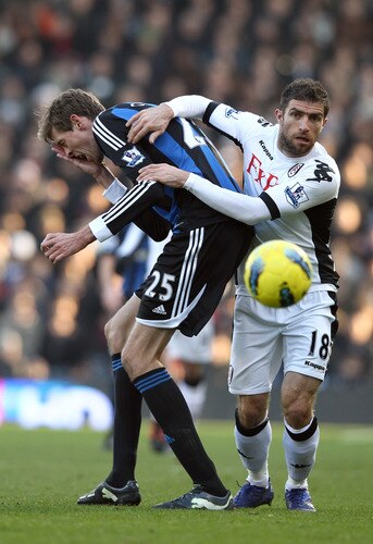 LONDON, ENGLAND - FEBRUARY 11:  Peter Crouch of Stoke City is tackled by Aaron Hughes of Fulham during the Barclays Premier League match between Fulham and Stoke City at Craven Cottage on February 11, 2012 in London, England.  <br /><br /><span class="help">(Photo by Ian Walton/Getty Images)</span>