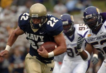 ANNAPOLIS, MD - SEPTEMBER 02:  In this handout photo Adam Ballard #22 of the Navy Midshipman is chased by Jarrett Wiggins #52 and C.J. Wilson #95 of the East Carolina Pirates in the first half of play at Navy-Marine Corps Memorial Stadium September 02, 2006 in Annapolis, Maryland.  (Photo by Damon J. Moritz/U.S. Navy via Getty Images)