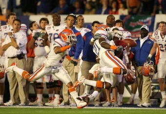 MIAMI - JANUARY 08:  Manuel Johnson #1 of the Oklahoma Sooners can't make a catch along the sideline as he is hit by Major Wright #21 of the Florida Gators during the FedEx BCS National Championship game at Dolphin Stadium on January 8, 2009 in Miami, Florida. Joe Haden #5 of the Gators trails on the play. FLorida won 24-14. (Photo by Doug Benc/Getty Images)